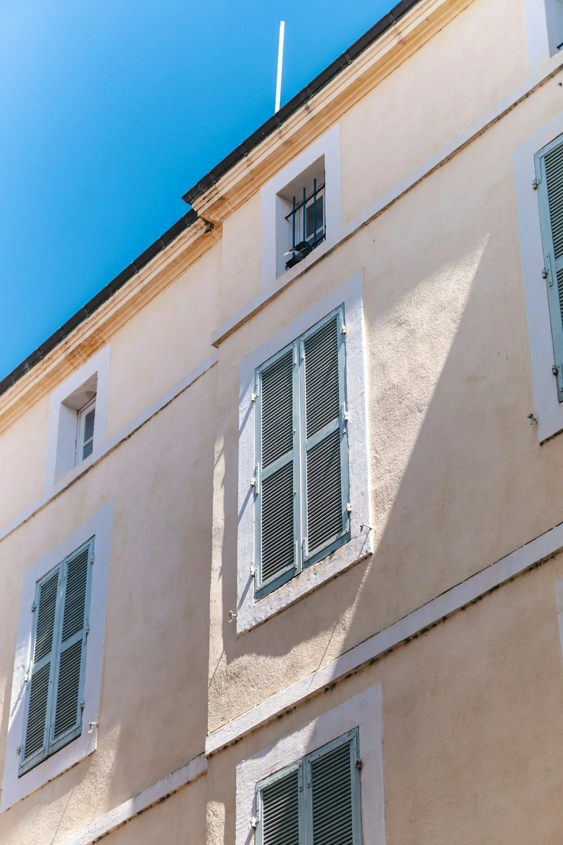 Façade d'immeuble français aux volets bleu clair